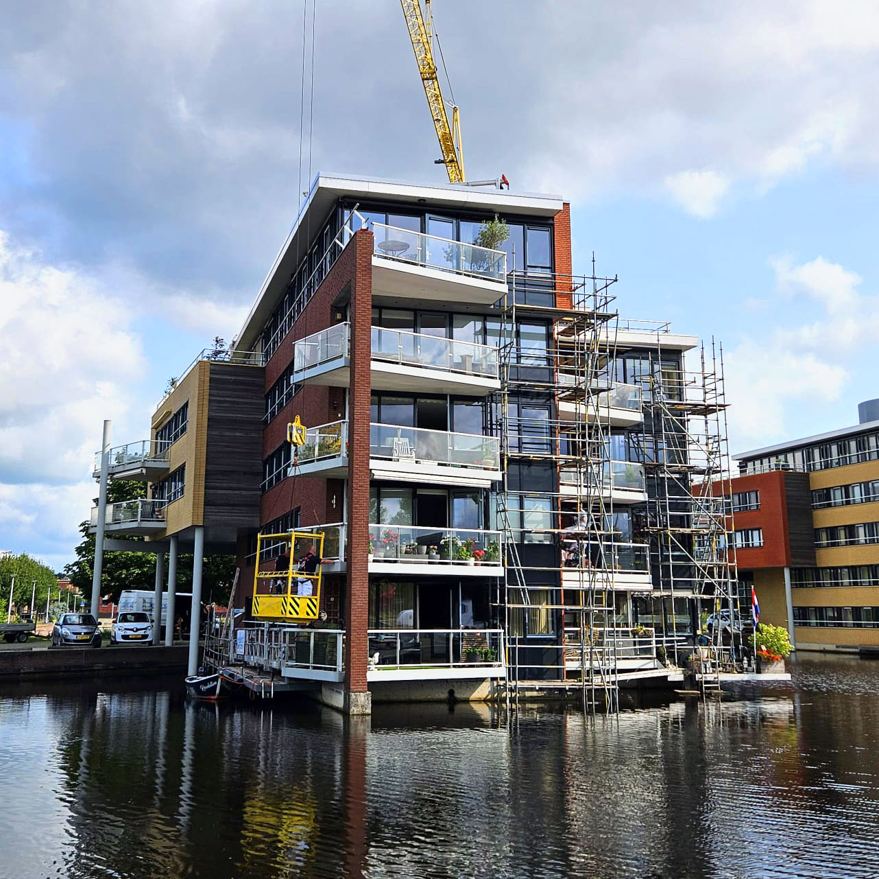 Schilder- en onderhoudswerkzaamheden aan woontoren VvE Gravenstate, uitgevoerd vanaf steigers en een ponton in het water